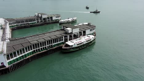 Tsim-Sha-Tsui-pier-with-ferry-docked-in-downtown-Hong-Kong,-Aerial-view