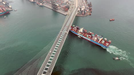 Cosco-mega-Container-Ship-crossing-Hong-Kong-Stonecutters-bridge,-heading-to-port