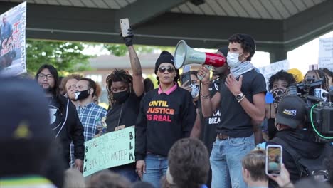 Impassioned-BLM-speaker-with-megaphone-on-stage-at-large-protest-rally