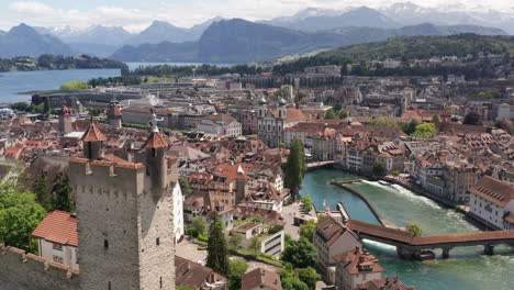 Aerial-overview-of-city-center-of-Luzern,-Switzerland-with-castle-tower-on-foreground