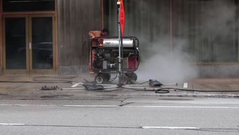 A-city-worker-sprays-sanitizer-up-and-down-a-public-sidewalk-to-clean-the-effects-from-covid-19,-coronavirus