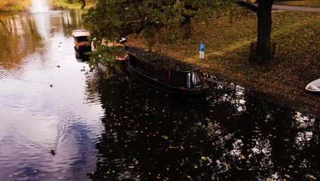 Small-boats-in-vibrant-golden-autumn-park-in-downtown-of-Riga