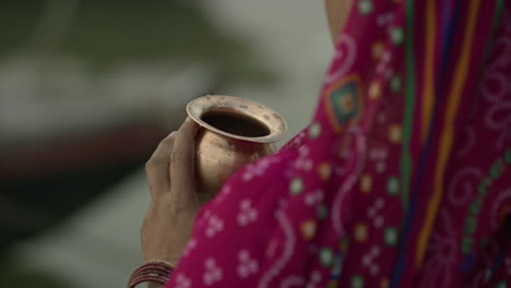 Woman-holding-a-gold-goblet-in-front-of-her