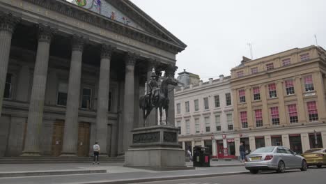 Wide-shot-of-female-skateboarders-practising-their-skills-behind-the-Duke-of-Wellington-statue