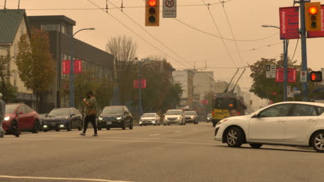 People-And-Vehicles-On-The-Busy-West-Hastings-Street-In-Vancouver,-British-Columbia-Under-The-Gloomy-Sky-With-Smoke-From-US-Wildfire---wide-shot