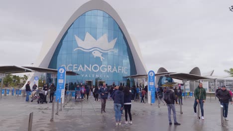 A-view-of-The-Oceanographic-with-tourists,-an-oceanarium-situated-on-the-dry-Turia-River-bed-to-the-southeast-of-the-city-center-of-Valencia,-Spain