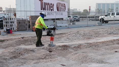 Construction-worker-using-equipment-to-tamp-the-ground