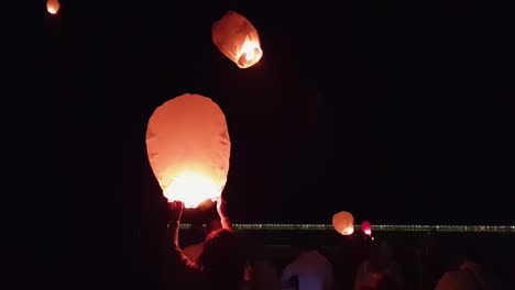 Crowd-of-people-and-Chinese-sky-fire-lanterns-flying-at-night