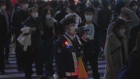 Policía-Hablando-A-La-Multitud-Usando-Un-Megáfono-En-La-Noche-De-Halloween-En-El-Cruce-De-Shibuya-En-Tokio,-Japón---Cámara-Lenta