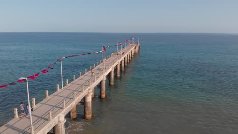 Flaggen-Wehen-Während-Des-Colombo-Festivals-über-Den-Gehweg-Am-Strand,-Der-Ins-Meer-Führt