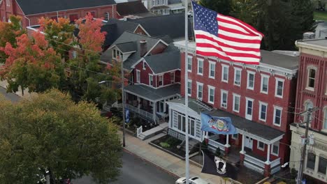 Aerial-reveal-shot-of-American-flag,-Pennsylvania-state,-POW,-MIA-flags-in-Small-Town-America,-USA