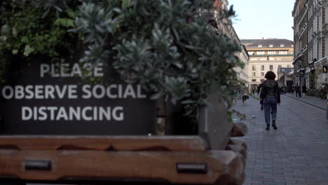 Menschen-Gehen-An-Einem-Schild-Auf-Einem-Dekorativen-Handkarren-Vorbei,-Auf-Dem-Steht:-„Bitte-Beachten-Sie-Die-Soziale-Distanzierung“-In-Einem-Sehr-Ruhigen-Covent-Garden-Während-Der-Zweiten-Nationalen-Sperrung-Des-Coronavirus