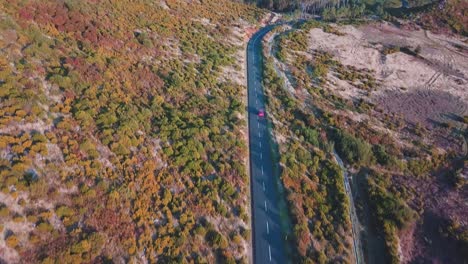 Red-Car-Driving-On-A-Isolated-Mountain-Road-1818-Meters-Above-Sea-Level-In-Madeira-Island,-Portugal---aerial-drone