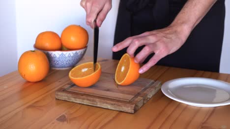Person,-Die-Orangen-In-Zwei-Hälften-Schneidet