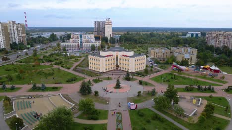 Aerial-view-away-from-the-Koledzh-Khoreohrafichnoho-Academy-over-the-Molodizhnyy-Park,-in-Troieshchyna-district,-cloudy-day,-in-Kiev-city,-Ukraine---pull-back,-tilt,-drone-shot