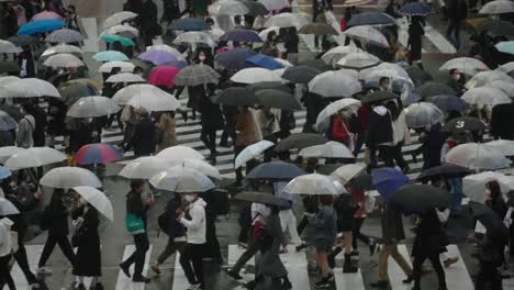 Japaner-Mit-Regenschirmen,-Die-In-Zeitlupe-An-Der-Shibuya-kreuzung-Bei-Kaltem-Regenwetter-Krabbeln---Nahaufnahme