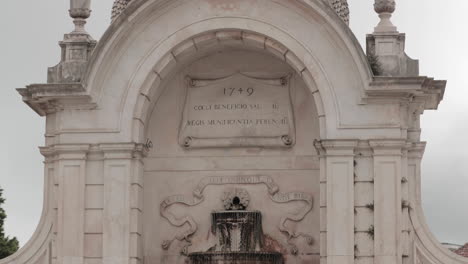 Una-Elegante-Fuente-De-Granito-Blanco-De-Dos-Niveles-De-Chafariz-Das-Cinco-Bicas-En-Caldas-Da-Rainha,-Leiria,-Portugal---Tiro-Inclinado-Hacia-Abajo