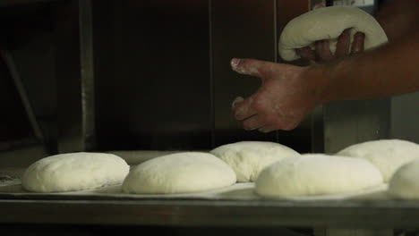 Placing-Bread-Dough-Dusted-With-Flour-On-A-Baking-Tray---close-up,-slider-shot
