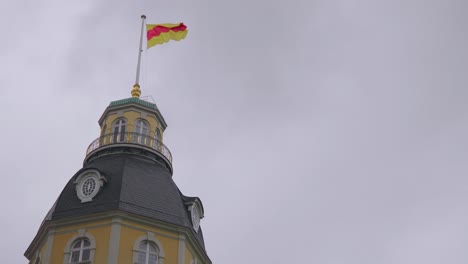 La-Bandera-De-Una-Torre-Del-Castillo-De-Kalsruhe-En-Un-Día-Ventoso-Y-Nublado-Que-Da-Un-Estado-De-ánimo-Triste