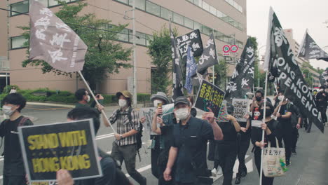 Demonstrators-With-Flags,-Banners,-And-Placards-Walking-In-Street-Of-Tokyo-Amidst-COVID-19---Solidarity-With-Hong-Kong-Protests---medium-shot