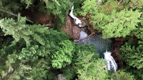 God-view-of-the-top-of-Franklin-Falls-cascading-into-a-clear-pool-of-mountain-fresh-water,-aerial