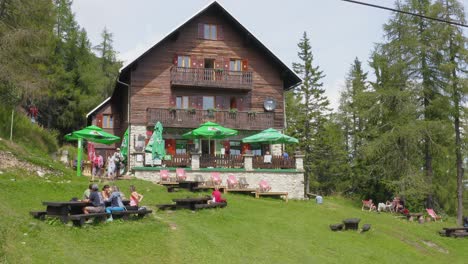 Visitors-Sitting-Outside-Dom-Na-Peci-Mountain-Hut-At-Koroska,-Mt