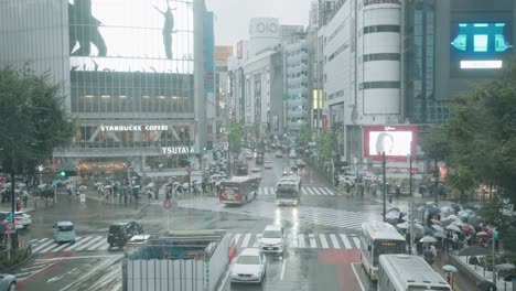 Tráfico-En-El-Cruce-De-Shibuya-Con-Peatones-En-Un-Día-Lluvioso-En-Tokio,-Japón