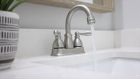 Close-up-pan-of-faucet-with-running-water
