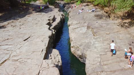 Los-Cangilones-de-Gualaca-Canyon,-Chiriqui-Province,-Panama,-Picturesque-Natural-Swimming-Baths-and-Visitors-on-Sunny-Day,-Tilt-Up-Drone-Aerial-View