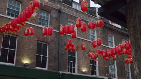 Linterna-China-Revelada-Desde-Un-Callejón-En-El-Barrio-Chino-De-Londres,-Balanceándose-En-El-Viento-En-Un-Día-Nublado