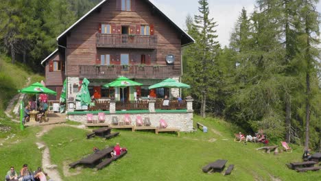 People-rest-and-eat-at-mountain-hut,-Little-Peca,-Crna-na-Koroskem