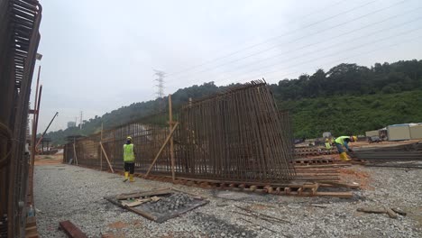 Bauarbeiter-Installieren---Fertigen-Holzschalungen-Und-Bewehrungsstäbe-Auf-Der-Baustelle