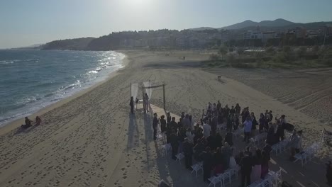 Extraordinaria-Boda-En-La-Playa-Con-El-Público-De-Pie-Y-Aplaudiendo,-Dando-Vueltas-En-El-Aire