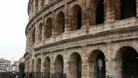 Zooming-out-from-the-facade-of-the-Colosseum-in-Rome,-Italy-in-a-rainy-day