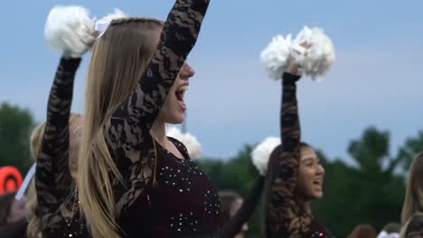 Highschool-Cheerleader-Jubeln-Mit-Der-Menge-Bei-Einem-Heimfußballspiel