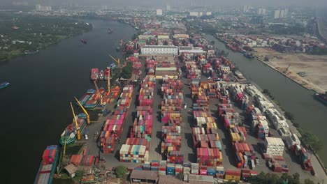 Vista-De-Drones-Del-Río-Saigón,-La-Ciudad-De-Ho-Chi-Minh-Y-La-Terminal-De-Carga-De-Contenedores-En-Un-Día-Soleado