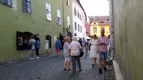 Familia-Y-Amigos-Caminando-Por-La-Acera-En-El-Centro-Histórico-De-Sighisoara,-Rumania-Durante-La-Pandemia-De-Covid-19,-Tiro-Estático