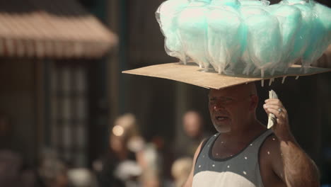 Straßenhändler,-Der-Während-Der-Parade-Zuckerwatte-Auf-Dem-Kopf-Balanciert,-Zeitlupe