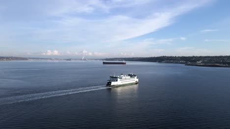 Un-Monte-Más-Lluvioso-Cubierto-De-Nubes-En-El-Fondo-Mientras-Un-Ferry-De-Washington-Cruza-El-Sonido-De-Puget,-órbita-Aérea