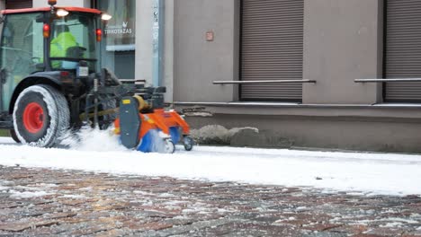 Snow-plower-tractor-cleaning-pavement-for-pedestrians