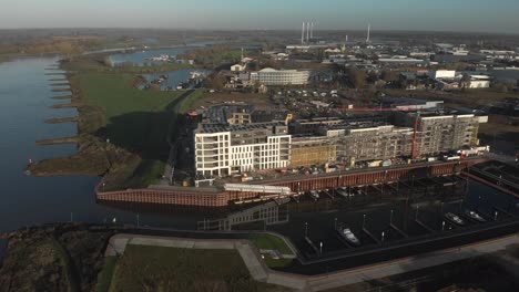 An-Einem-Sonnigen-Tag-Entlang-Der-Ijssel-Liegen-Überschwemmungsgebiete-Und-Ein-Im-Bau-Befindliches-Modernes-Neues-Luxusapartmentgebäude-Neben-Einem-Freizeithafen-Mit-Industrie