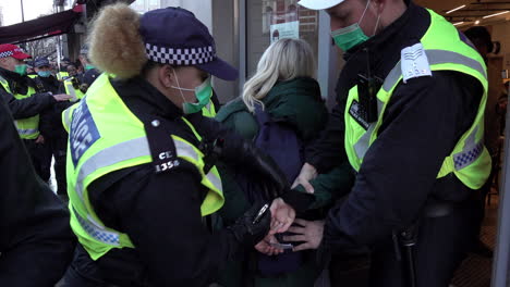 London-Metropolitan-police-officers-detain-a-woman-and-retrain-her-in-speed-cuffs-during-a-protest-that-breached-Coronavirus-health-and-safety-legislation