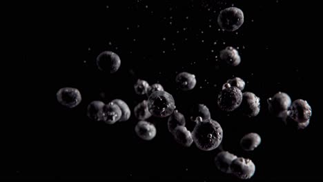 Currants-Falling-into-Water-Super-Slowmotion,-Black-Background,-lots-of-Air-Bubbles,-4k240fps