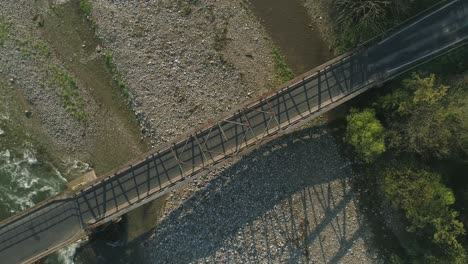Top-down-aerial-of-steel-frame-bridge-crossing-Bialke-river-in-Poland