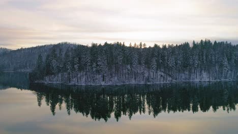 Winter-lake-with-tree-mirror-reflection-during-sunset