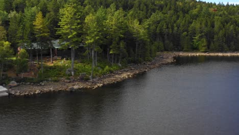 Frühherbst-Luftaufnahmen-Eines-Abgelegenen-Sees-Im-Norden-Von-Maine,-Der-Direkt-An-Einem-Lager-Vorbeigleitet