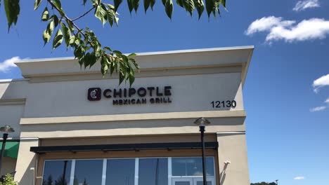 El-Exterior-De-Un-Restaurante-Tex-mex-Informal-Rápido-De-Chipotle-En-Un-Centro-Comercial-En-Portland,-Oregon,-Ee.uu.-Con-Una-Bandeja-De-Mano-A-Través-De-Algunos-árboles