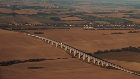 Aerial-view-of-highway-bridge-in-Countryside-with-orange-fields