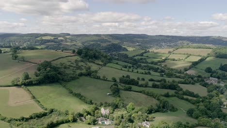 Aerial-fly-over-of-the-acres-of-countryside-and-rolling-hills-surrounding-Embercombe-on-the-edge-of-Dartmoor,-United-Kingdom
