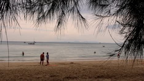 Disparó-A-Través-De-Un-árbol-De-Agujas-En-La-Playa-De-Tailandia-Con-Gente-Feliz-Jugando-Y-Bailando-En-La-Arena